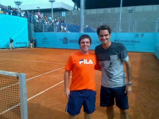Juan Pablo Pagano junto a un tenista en una cancha de polvo de ladrillo
