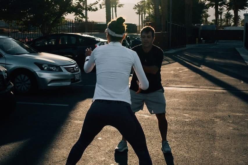 Juan Pablo Pagano realizando un ejercicio de activación con una atleta al aire libre